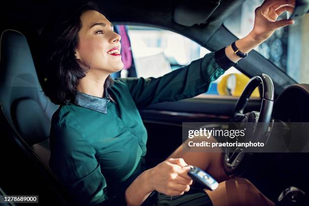 woman is enjoying new car in a showroom - audi showroom stock pictures, royalty-free photos & images