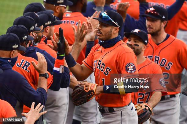 Carlos Correa of the Houston Astros celebrates the teams 10-5 win against the Oakland Athletics with his teammates in Game One of the American League...