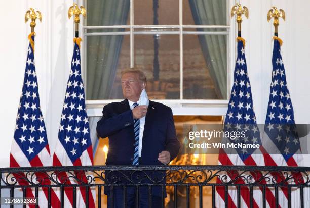 President Donald Trump removes his mask upon return to the White House from Walter Reed National Military Medical Center on October 05, 2020 in...