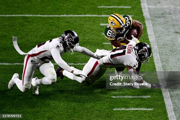 Malik Taylor of the Green Bay Packers is tackled by Sharrod Neasman of the Atlanta Falcons during the first half at Lambeau Field on October 05, 2020...