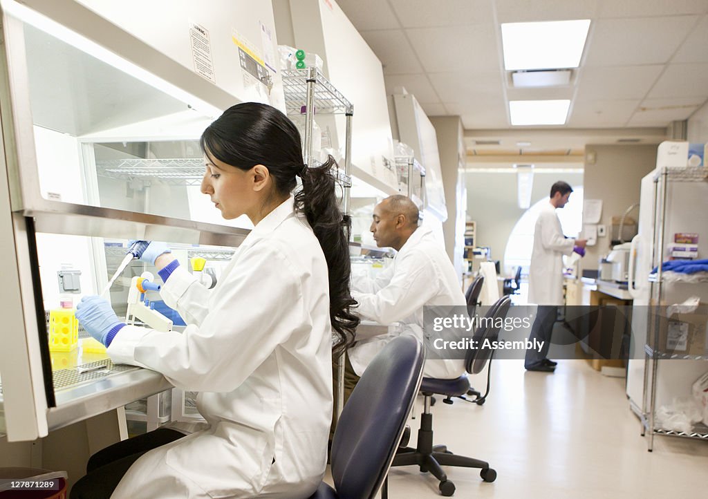 Female scientist drops liquid into test tube