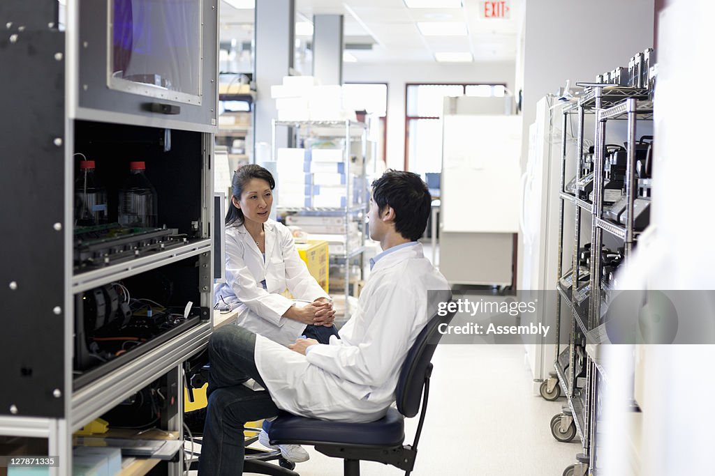Laboratory technician talks with colleague in lab