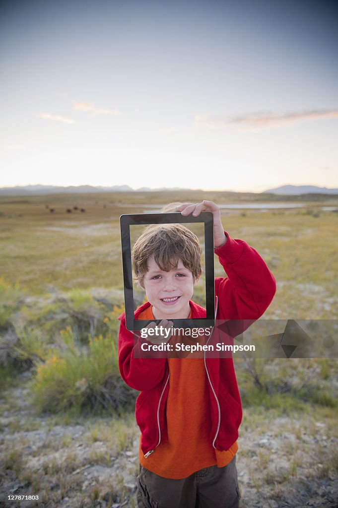 Boy showing his portrait on tablet computer