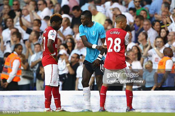 Emmanuel Adebayor of Tottenham Hotspur shakes the hands of his former team mates Alex Song and Kieran Gibbs of Arsenal during the Barclays Premier...