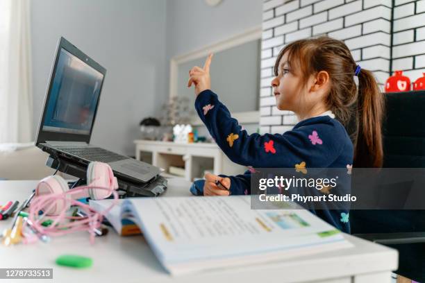 little girl student video conference e-learning with teacher and classmates on computer in living room at home. homeschooling and distance learning ,online ,education and internet - online coach stock pictures, royalty-free photos & images