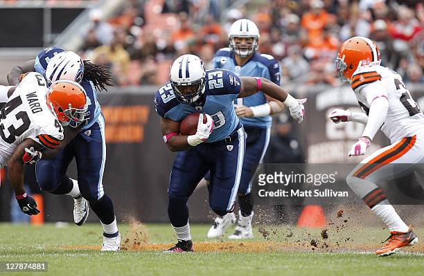 Running back Jamie Harper of the Tennessee Titans runs by defenders T.J. Ward and Joe Haden of the Cleveland Browns at Cleveland Browns Stadium on...