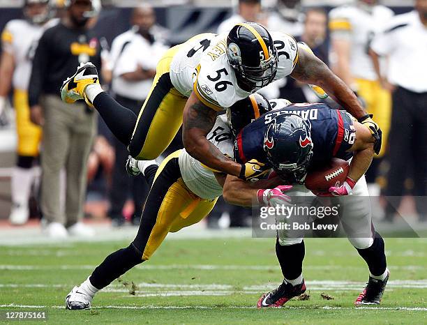 Tight-end Owen Daniels of the Houston Texans is tackled by linebacker Larry Foote and linebacker LaMarr Woodley of the Pittsburgh Steelers in the...