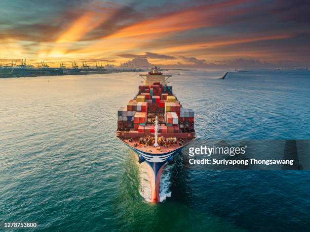 aerial front view container cargo ship full carrier container with terminal commercial port background for business logistics, import export, shipping or freight transportation. - freight transportation stock-fotos und bilder