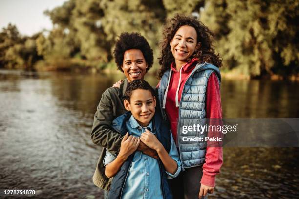 mother posing for a photo with her kids near the river - lean in collection stock pictures, royalty-free photos & images