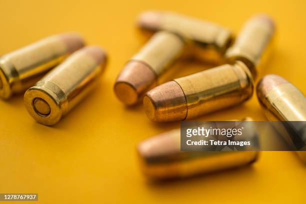 brass bullets on yellow background - bullets stock pictures, royalty-free photos & images