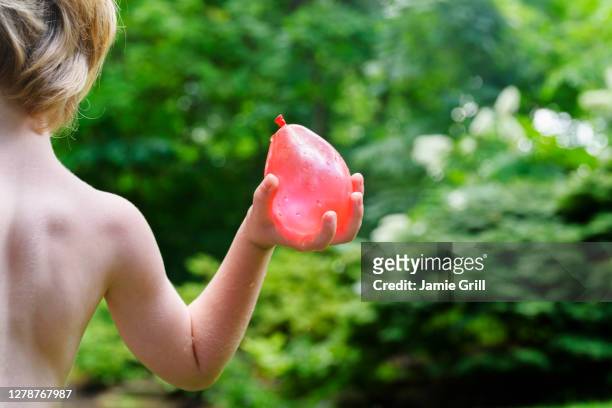 boy (4-5) playing with water balloons - throwing water stock pictures, royalty-free photos & images