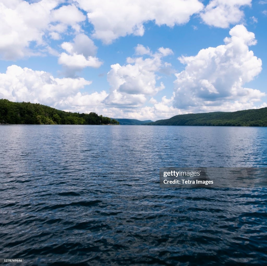 USA, New York, Cooperstown, Otsego Lake, Clouds over lake surrounded by hills
