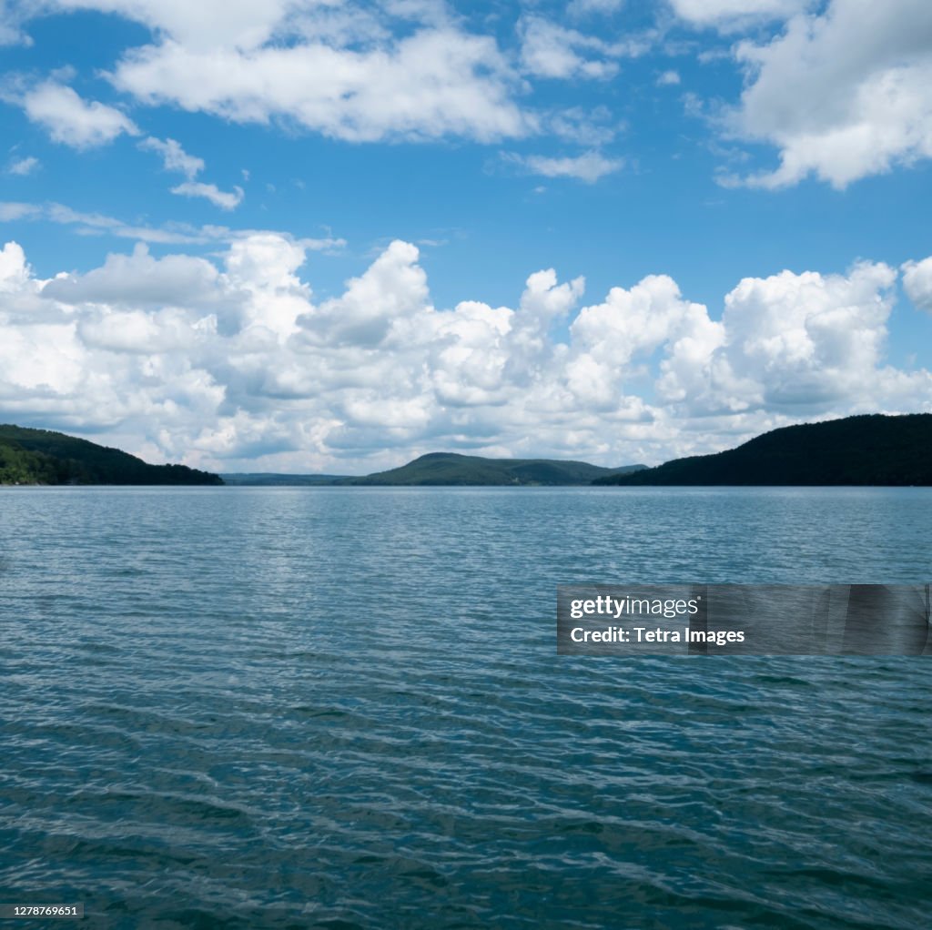 USA, New York, Cooperstown, Otsego Lake, Clouds over lake surrounded by hills