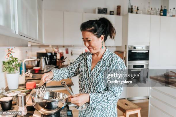 frau rührt teig für hausgemachtes brot in der küche - asian cooking stock-fotos und bilder