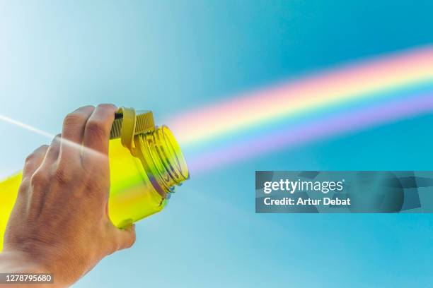 creative picture capturing rainbow with reusable water bottle in the sky. - project greenlight stock pictures, royalty-free photos & images