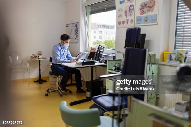 doctor wearing face mask having a telemedicine - general practitioner ストックフォトと画像