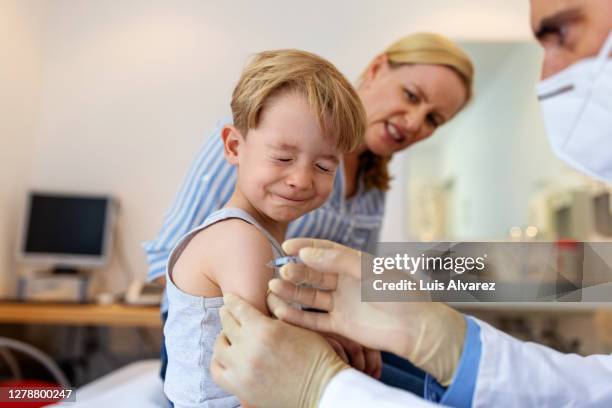 little boy feeling pain while getting a vaccine - injecteren stockfoto's en -beelden