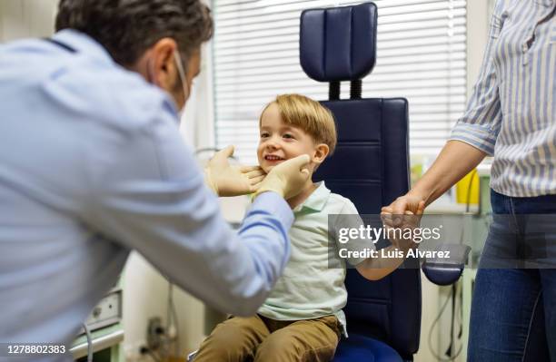 ent doctor examining throat of a boy in clinic - human gland stockfoto's en -beelden