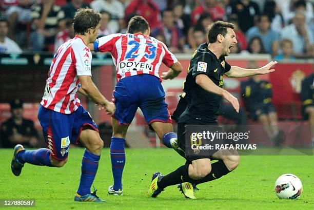 Barcelona's Argentinian forward Lionel Messi cries as he is tackled by Sporting Gijon's forward David Barral , during the Spanish league football...