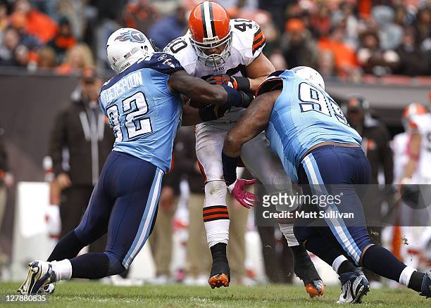 Running back Peyton Hillis of the Cleveland Browns is tackled by defenders Will Witherspoon and William Hayes of the Tennessee Titans at Cleveland...