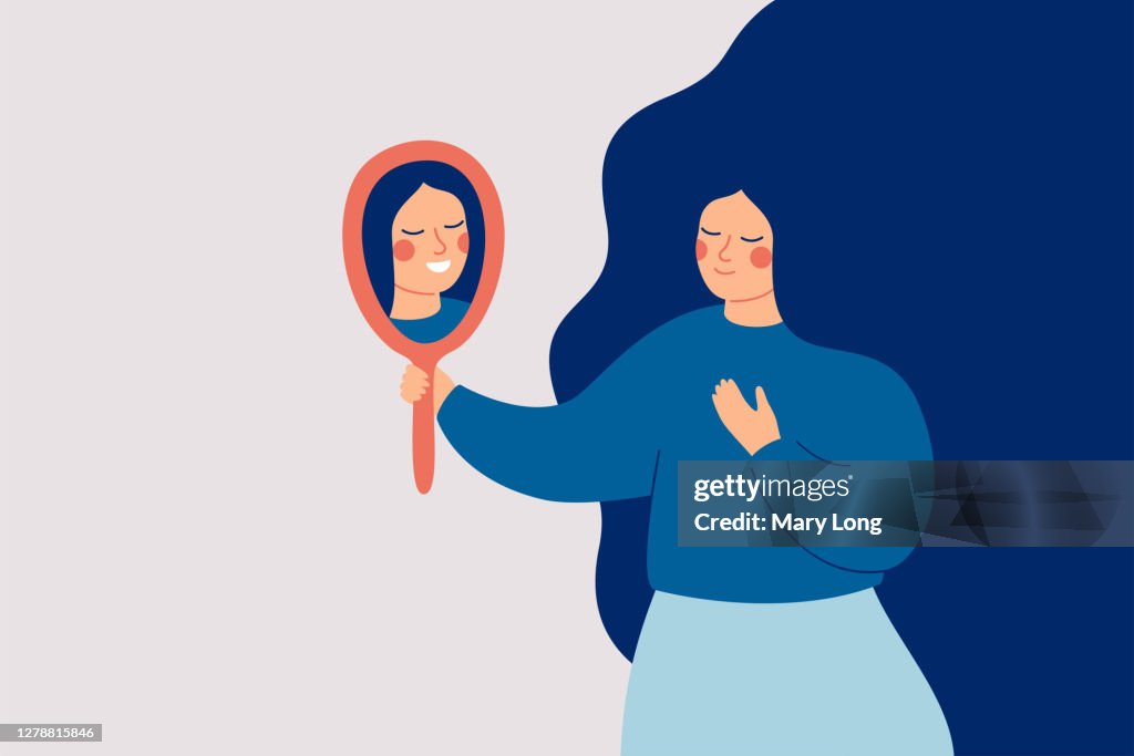 Young woman looks at the mirror and sees her happy reflection.