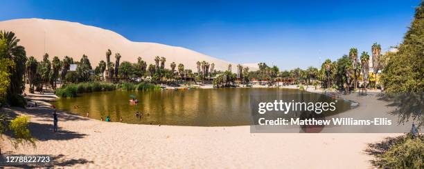 huacachina lagoon in huacachina, a desert oasis surrounded by sand dunes, ica region, peru, south america - huacachina stock pictures, royalty-free photos & images