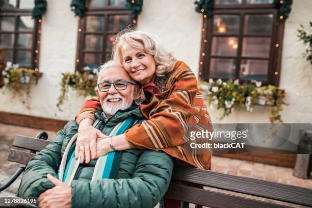 happy senior couple enjoying in the city during winter - active retirement community stock pictures, royalty-free photos & images