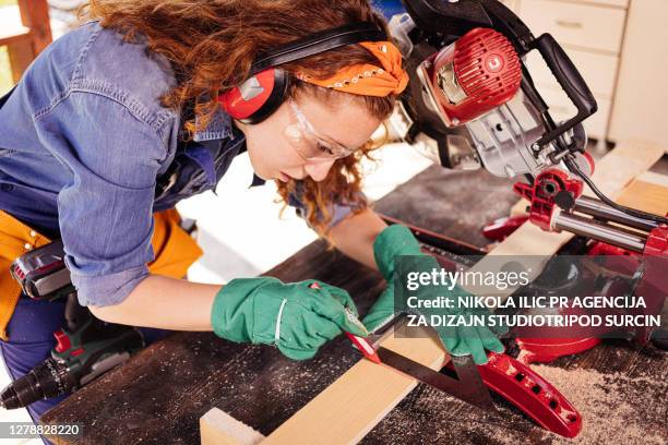 young female carpenter with a miter saw. - mitre stock pictures, royalty-free photos & images