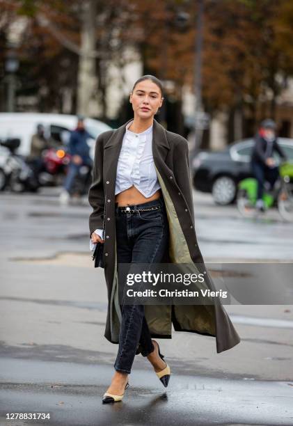 Sophia Roe is seen wearing white cropped top, grey coat, denim jeans, black bag, heels outside Chanel during Paris Fashion Week - Womenswear Spring...