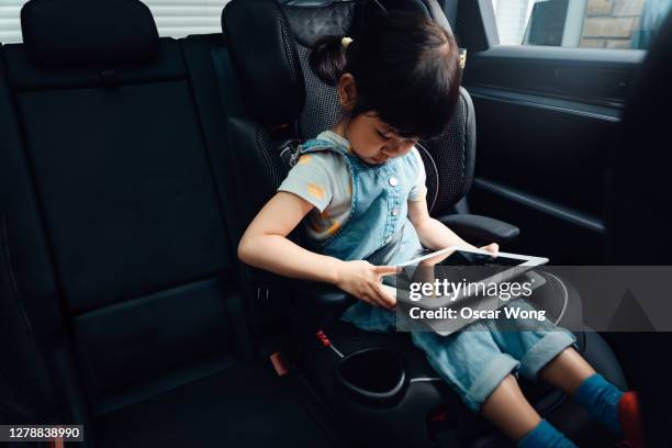 young girl using digital tablet in the car - girl in car with ipad stock-fotos und bilder