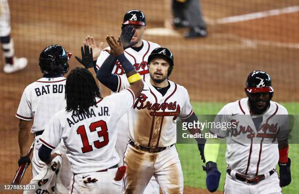 Travis d'Arnaud of the Atlanta Braves is congratulated by teammates after hitting a three run homerun during the seventh inning against the Miami...