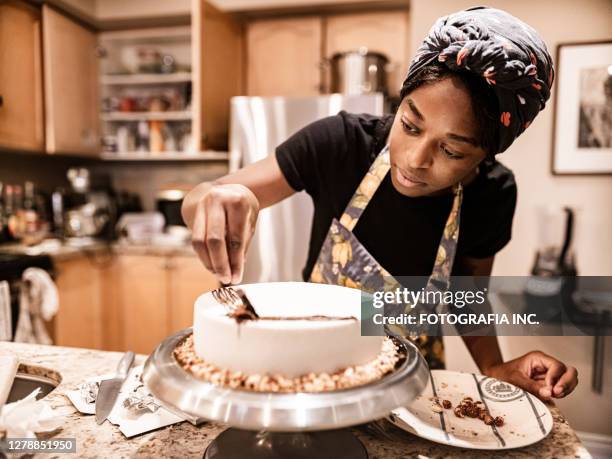 young woman baking - decorar um bolo imagens e fotografias de stock