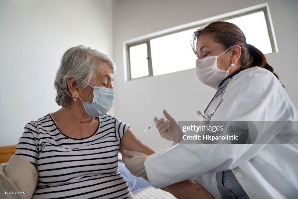 Senior woman getting a COVID-19 vaccine at a nursing home