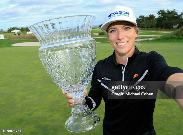 Mel Reid of England holds the trophy while pretending to take a selfie after winning the ShopRite LPGA Classic presented by Acer on the Bay Course at...