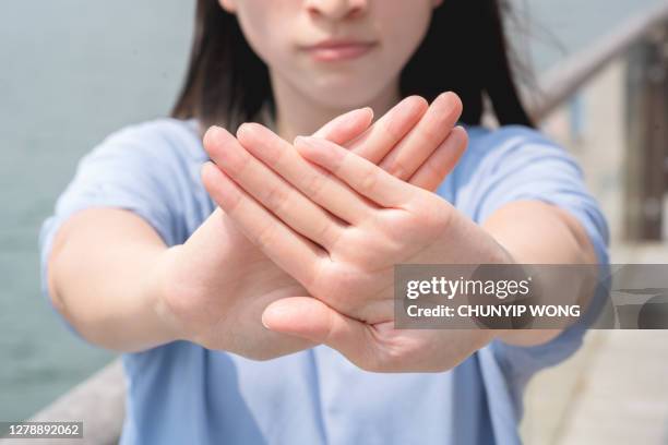 women making stop gesture with two crossed palms - banchina stock pictures, royalty-free photos & images