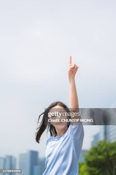 asiatische frau zeigt ihren finger zu bestätigen - raised finger stock-fotos und bilder