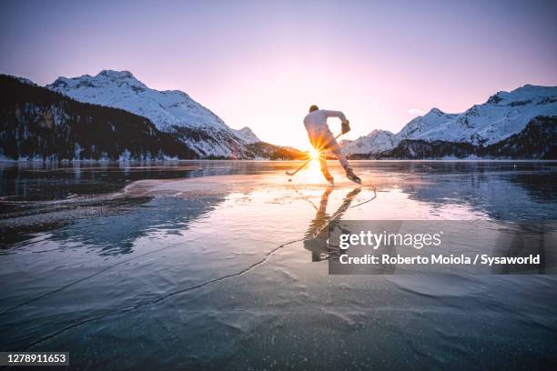 ice hockey player skating on frozen lake sils, switzerland - frozen lake stock pictures, royalty-free photos & images
