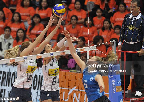 Brazil's Thaisa Menezes and Jaqueline Carvalho block a spike from Argentina's Lucia Fresco, during their 2011 Women's South American Volleyball...