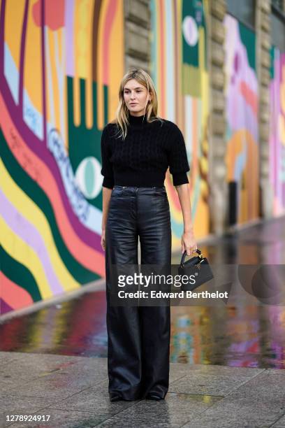 Camille Charriere wears a black turtleneck pullover, black leather flared pants, a Vuitton bag, outside Louis Vuitton, during Paris Fashion Week -...