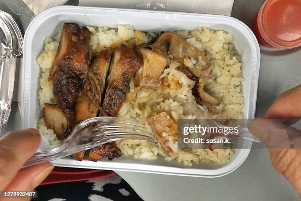 directly above shot of man eating economy class lunch set on the plane. - plane food stock pictures, royalty-free photos & images