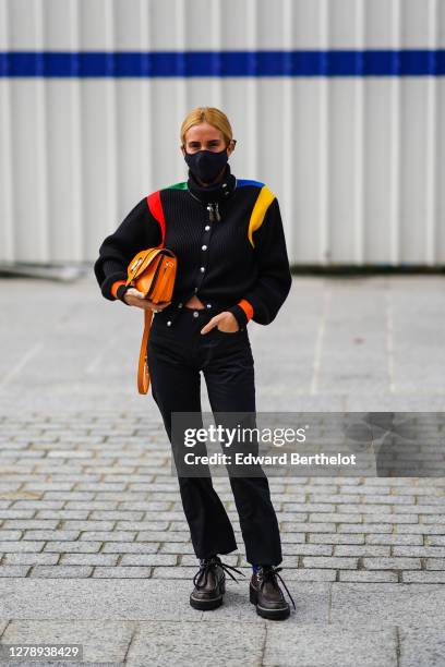 Blanca Miro wears, a black jacket with colored stripes, an orange Vuitton leather bag, black jeans, brown leather monogram print Vuitton shoes,...