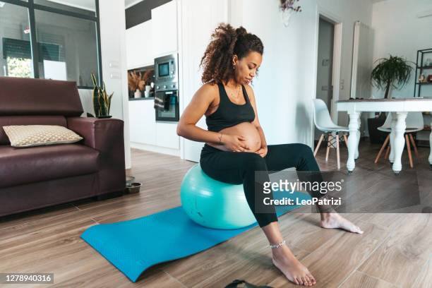 schwangere frau ausübung wie zu hause fühlen. - pilates ball man stock-fotos und bilder