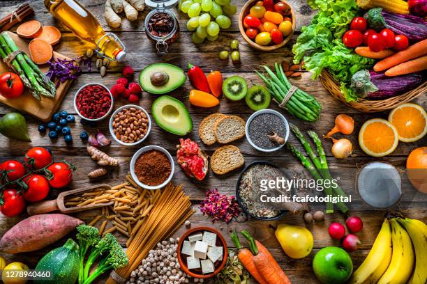 vegane lebensmittelhintergründe: große gruppe von obst, gemüse, getreide und gewürzen von oben geschossen - speisen und getränke stock-fotos und bilder