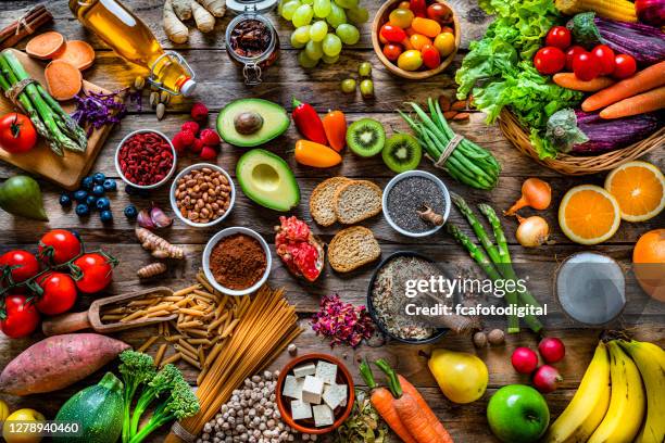 fondos alimentarios veganos: gran grupo de frutas, verduras, cereales y especias desde arriba - comida básica fotografías e imágenes de stock