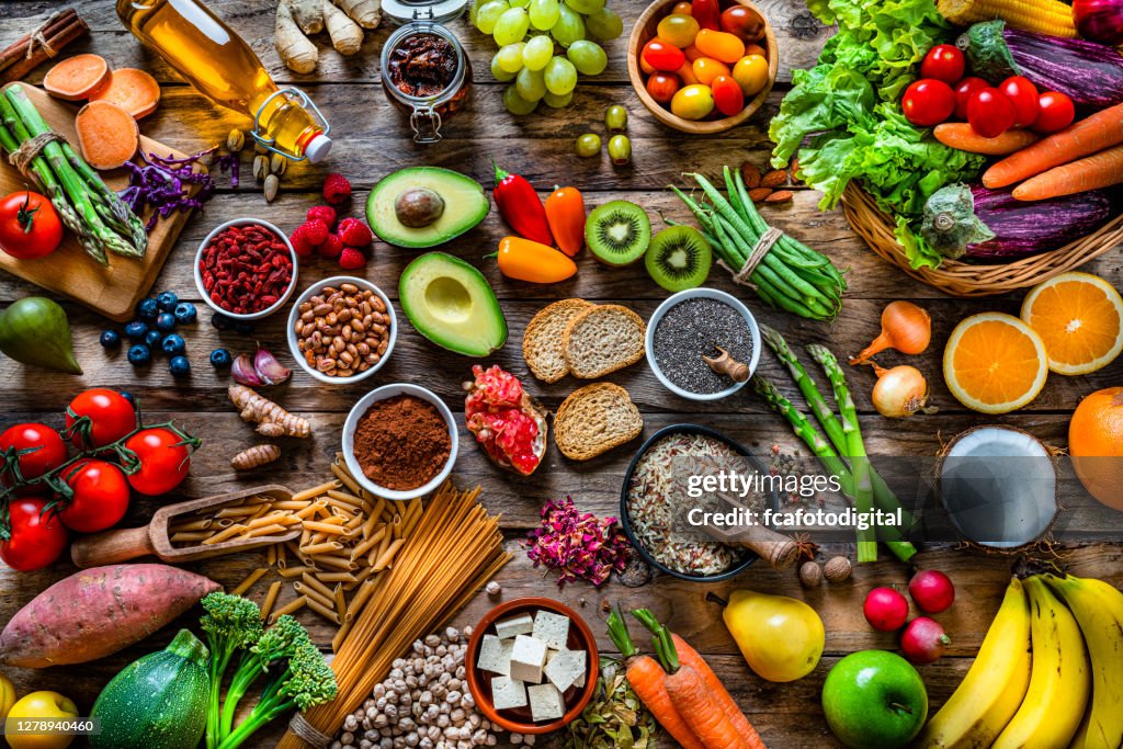 Vegan food backgrounds: large group of fruits, vegetables, cereals and spices shot from above