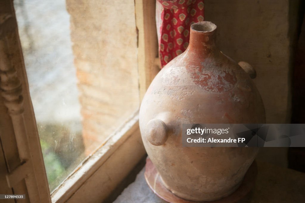 Old terracotta jar at window