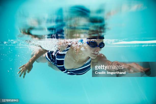 teenage girl swimming crawl in pool - swimming stock pictures, royalty-free photos & images