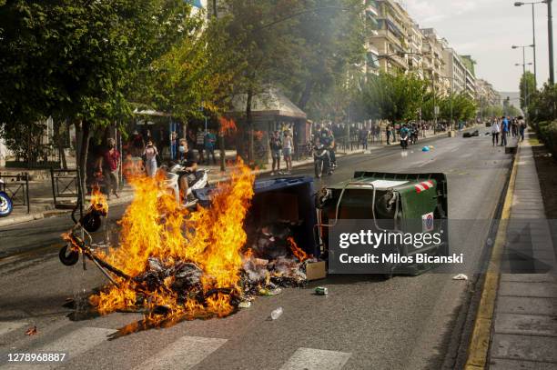 Bin is set on fire as anti-fascist protesters demonstrate outside the court, where the trial of leaders and members of the Golden Dawn far-right...