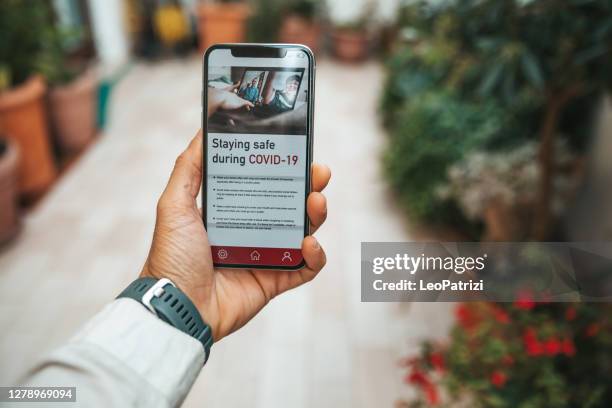 covid news on mobile phone. wear a mask reminder - article stock pictures, royalty-free photos & images