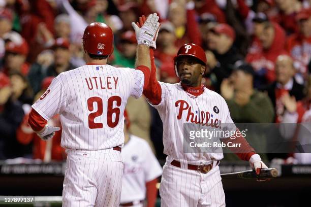 Jimmy Rollins and Chase Utley of the Philadelphia Phillies celebrate after scoring on a Ryan Howard RBI single in the first inning against the St....